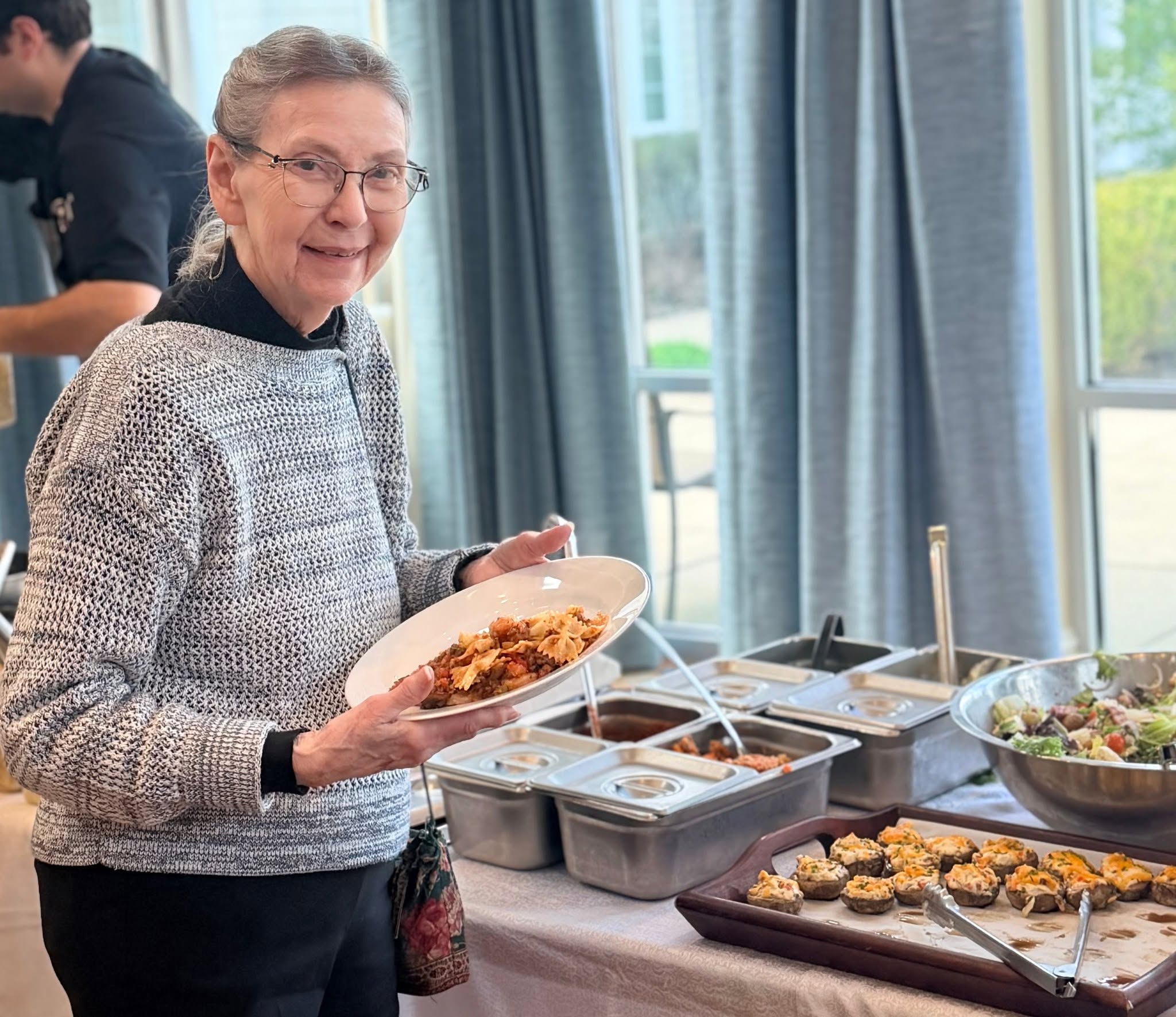 A resident serving herself from the chef's buffet